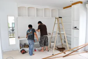 ช่างติดตั้งตู้ทีวีและชั้นโชว์สีขาวในบ้าน Nirvana Beyond