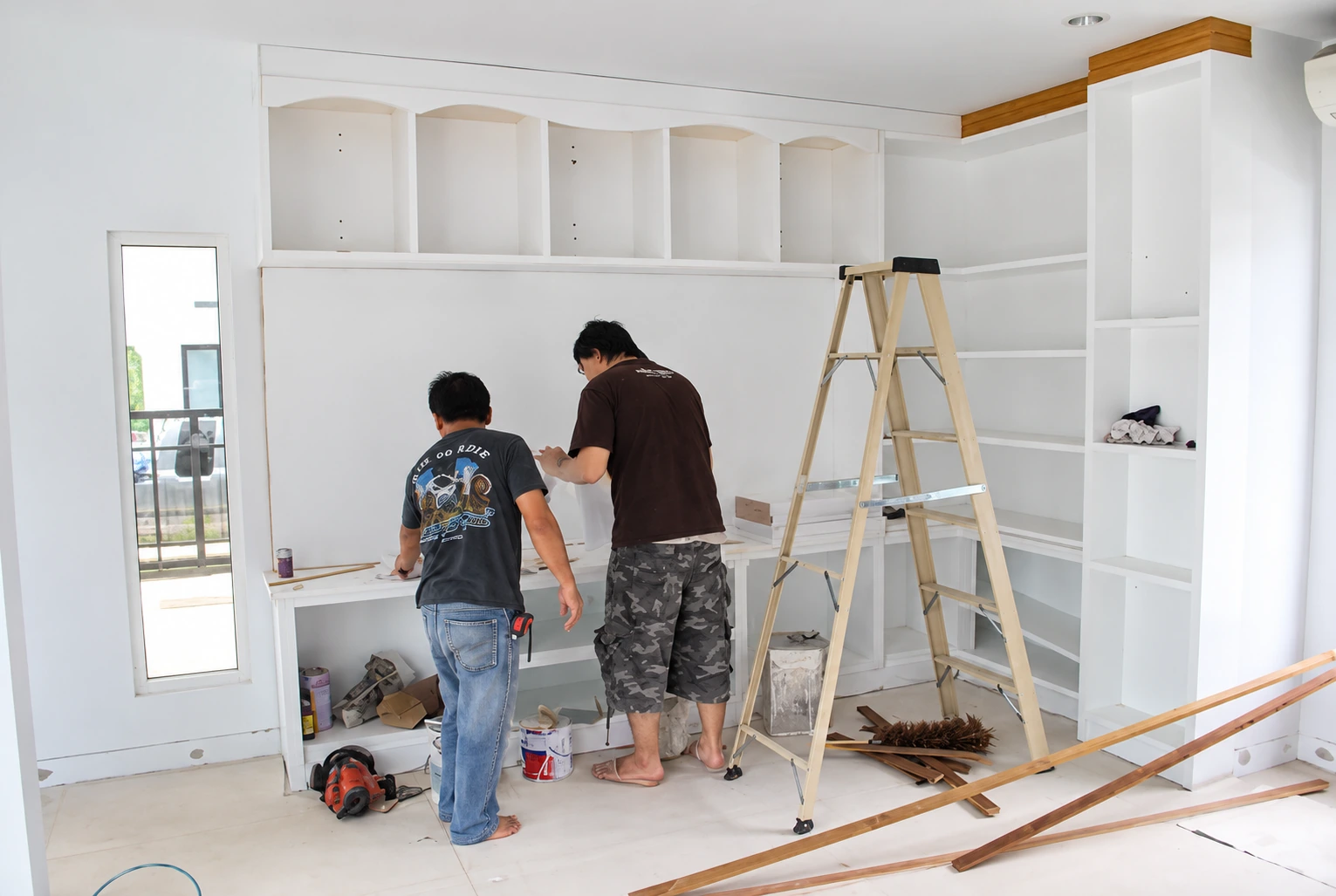 ช่างติดตั้งตู้ทีวีและชั้นโชว์สีขาวในบ้าน Nirvana Beyond