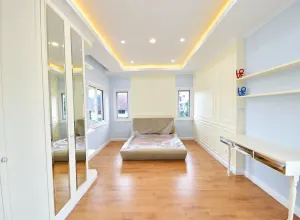 มุมห้องนอนพร้อมโต๊ะยาวและชั้นวาง บ้านสร้างเอง เขตจตุจักร กรุงเทพฯ
